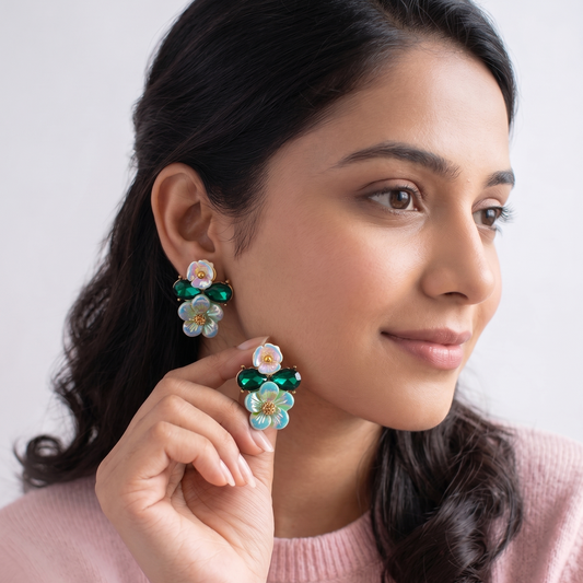 Woman wearing colorful floral earrings against a plain background