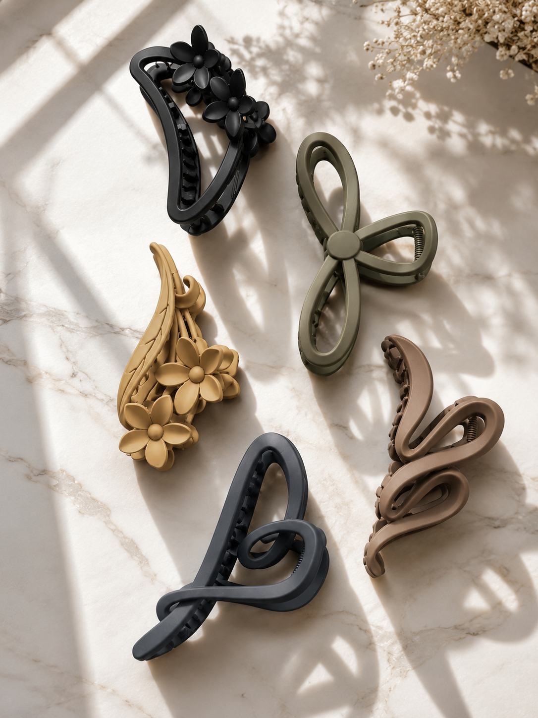 Set of five decorative wall hooks in various shapes and colors on a light surface.