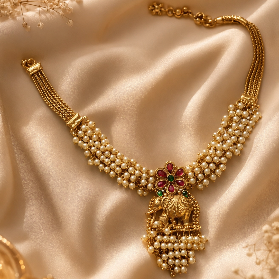 Gold necklace with intricate design on a beige fabric background
