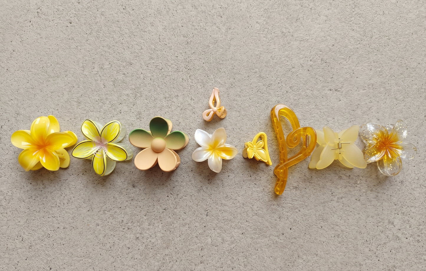 Set of colorful flower-shaped hair clips on a textured beige background