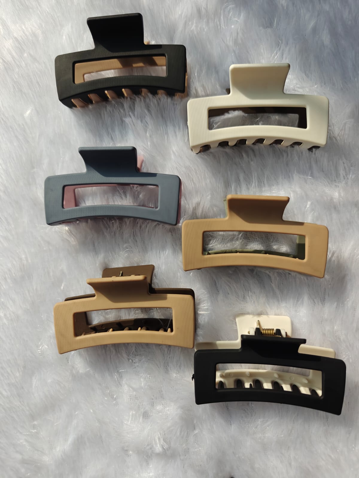 Set of six hair clips in different colors on a textured gray background