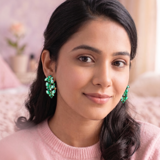 Woman wearing green earrings with a blurred background