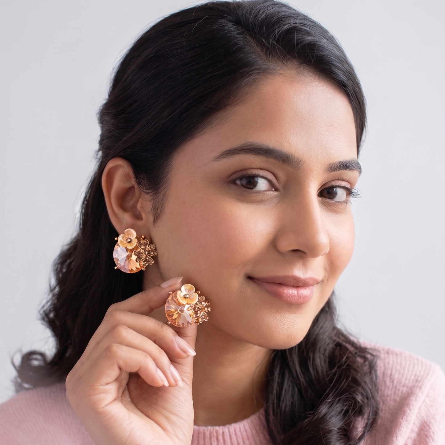 Woman wearing floral earrings against a light background