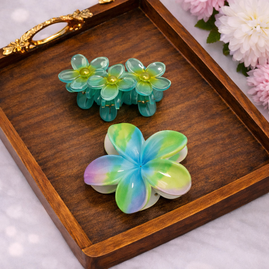 Colorful flower-shaped hair clips on a wooden tray with flowers in the background