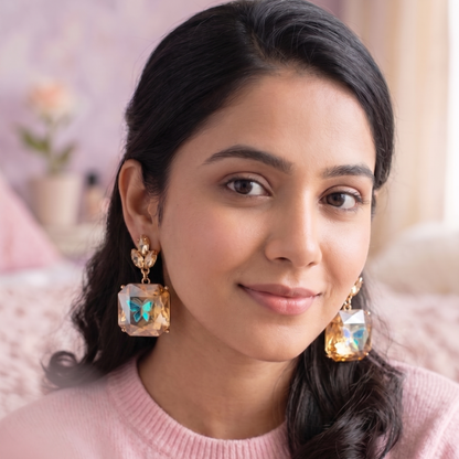 Woman wearing large, ornate earrings with a soft focus background