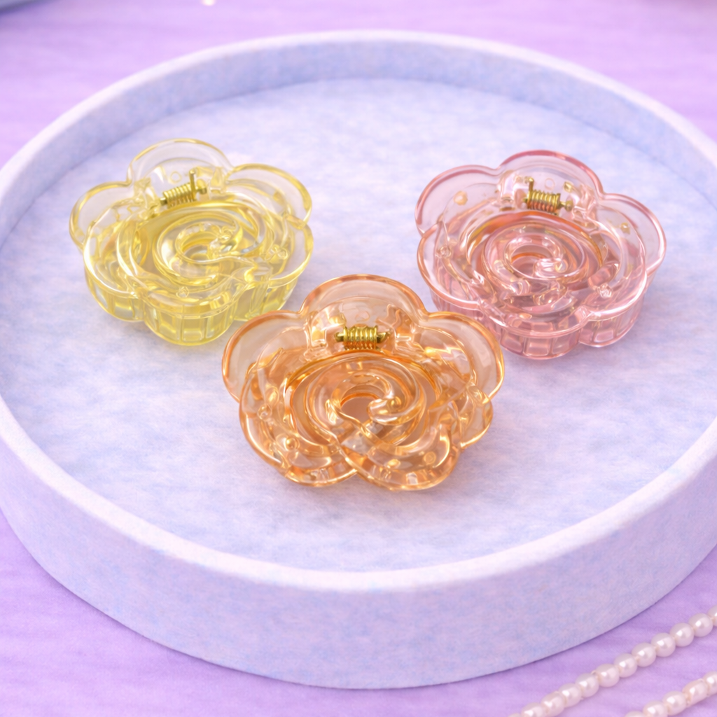 Three colorful flower-shaped hair clips on a white plate with a purple background.