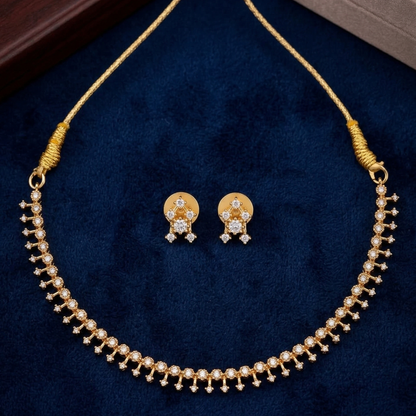 Gold plated necklace and earrings set on a blue velvet background