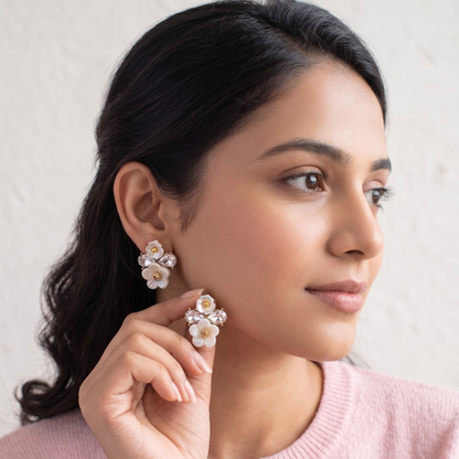 Woman wearing floral earrings with a plain background