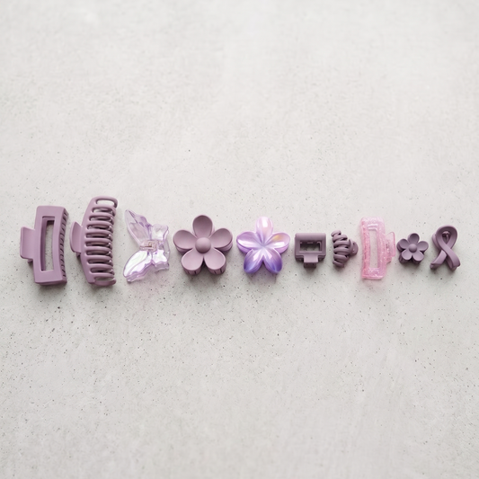Set of various hair clips on a light gray background