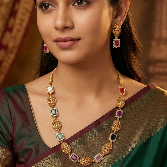 Woman wearing gold jewelry with gemstones against a warm-toned background