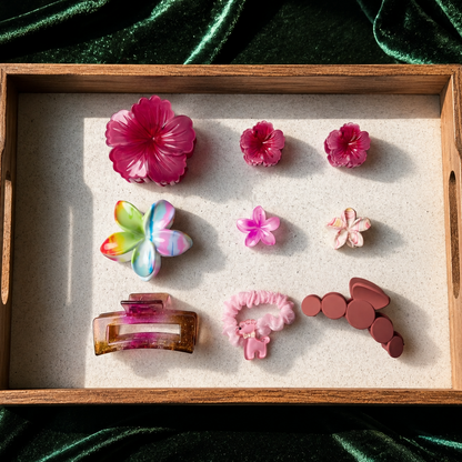 Wooden tray with colorful hair accessories on a green fabric background