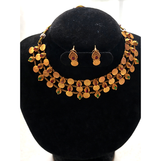 Gold necklace and earrings set on a black velvet stand