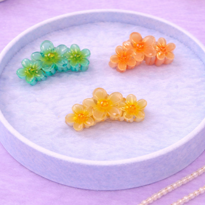 Colorful floral earrings on a white dish with a purple background