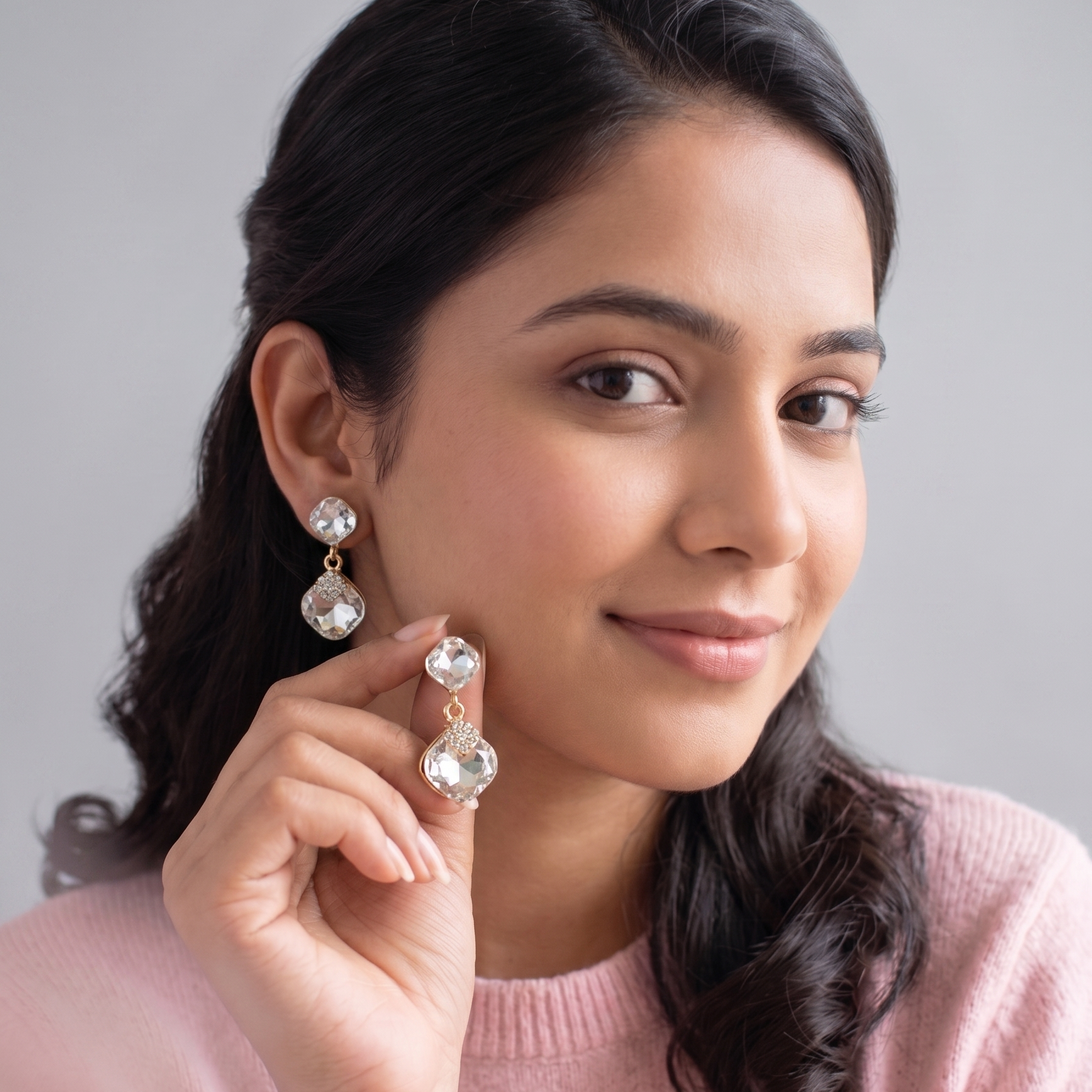 Woman wearing earrings with a plain background