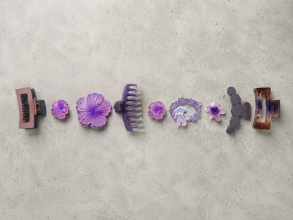 Set of purple hair clips on a gray surface