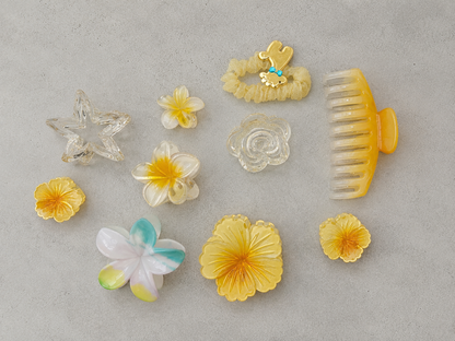 Collection of various hair accessories including flowers and a comb on a gray background