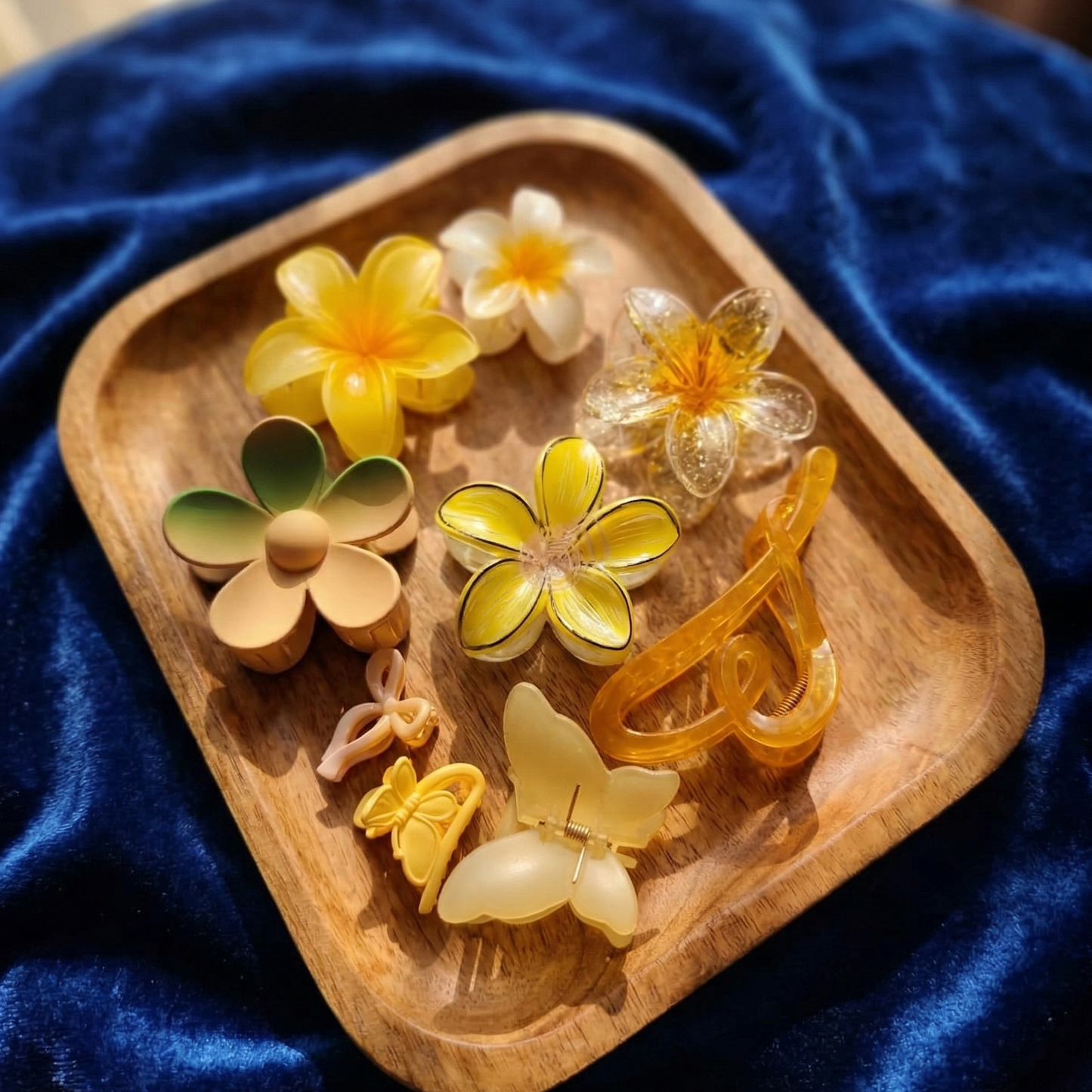 Wooden tray with floral-shaped hair clips on a blue velvet background