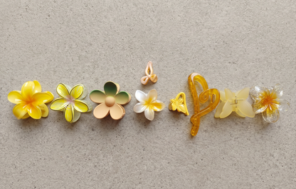 Set of colorful flower-shaped hair clips on a textured beige background
