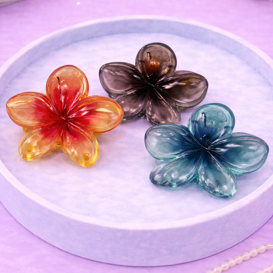 Three colorful flower-shaped objects on a white plate with a purple background.