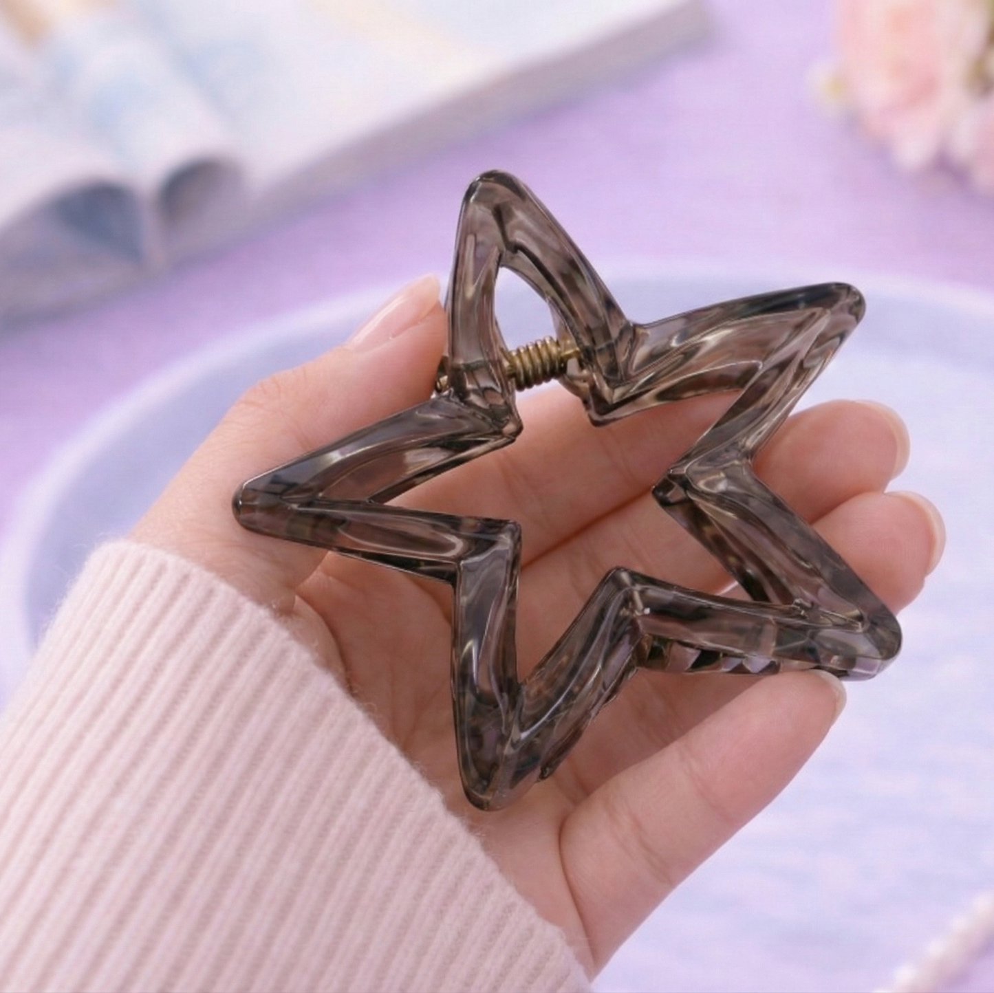 Star-shaped hair clip held in a hand with a soft focus background