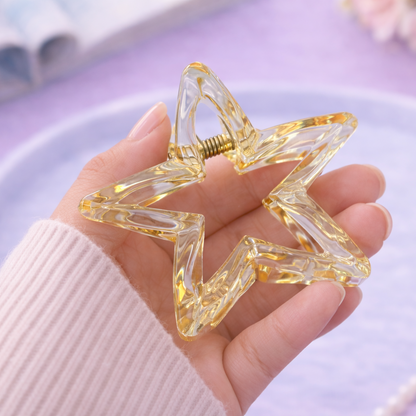 Hand holding a yellow hair clip with a geometric design on a light purple background